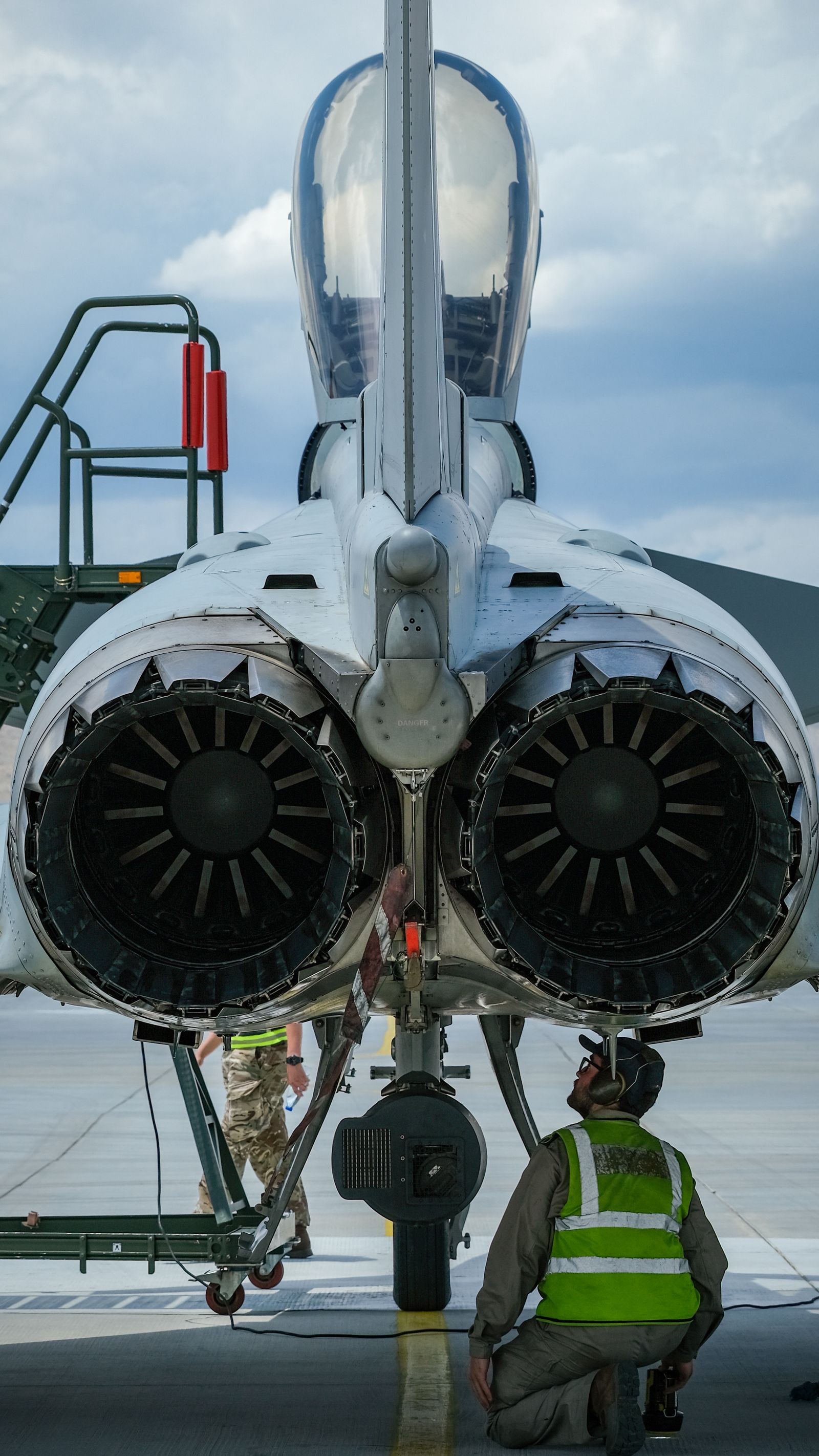 Aerospace technicians inspecting a military aircraft on the flight line