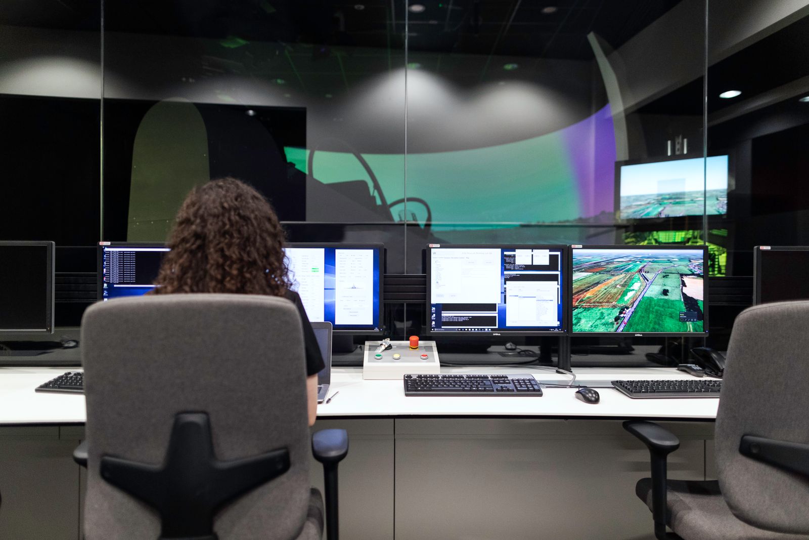 Engineer monitoring geospatial systems in a technology control room