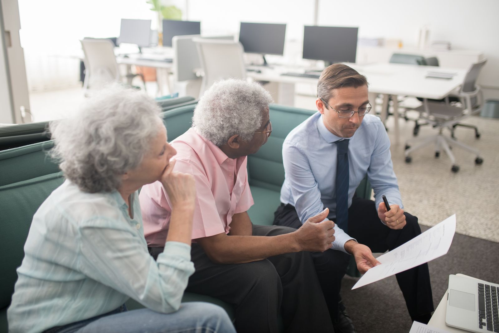 Financial adviser reviewing documents with clients in an office