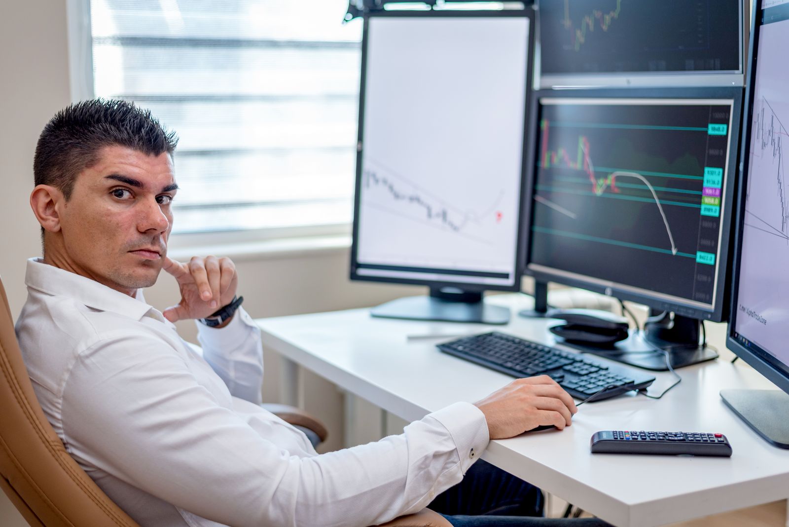 Market analyst monitoring financial data across multiple screens